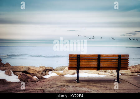 Eine Parkbank mit Blick auf den gefrorenen Bucht von Green Bay, Wisconsin. Stockfoto