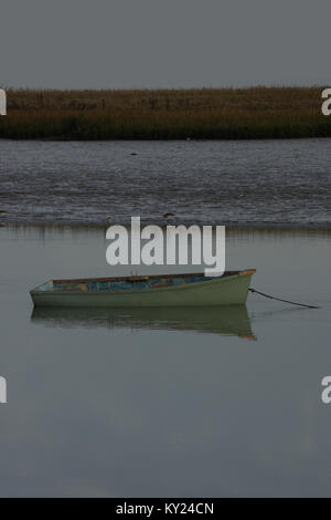 Holzboot mit Reflexion über Wasser, Schilf Banken im Hintergrund. Kopieren Platz Oben und Unten. Stockfoto