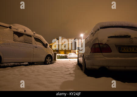 Verschneite Straße Szene auf einem kalten Dezember Abend, von der Einfahrt zu einem der Häuser. Auf der Suche nach weiß winter Straße bei Nacht. Stockfoto