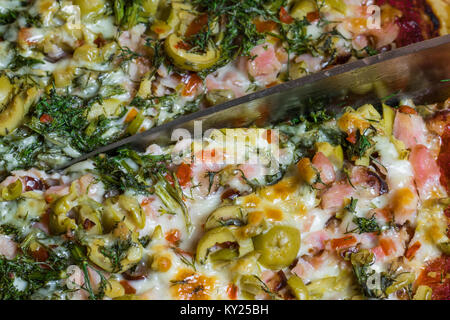 Frische Pizza serviert auf einem rustikalen Holztisch. Stockfoto