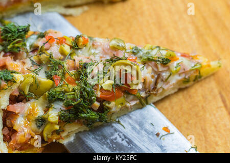 Frische Pizza serviert auf einem rustikalen Holztisch. Stockfoto