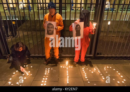 London, Großbritannien. 11 Jan, 2018. London, Großbritannien. 11. Januar 2018. Eine Mahnwache außerhalb der US-Botschaft zum 16. Jahrestag der illegale Folter Lager in Guantanamo Bay, wo 41 Gefangenen noch gehalten werden gekennzeichnet, vor allem statt auf unbestimmte Zeit ohne Anklage oder Gerichtsverfahren und die meisten mit ständigen Verletzungen durch Folter, dass ihre Freilassung peinlich in die USA (und möglicherweise auch UK) Behörden machen würde. Die demonstranten Kerzen vor der Botschaft zaun Schreibweise "GITMO" und dann stand halten Sie Kerzen und große Fotos der 41 verbleibenden Häftlinge, die meisten sie vor mehr als zehn Jahren in der Stockfoto