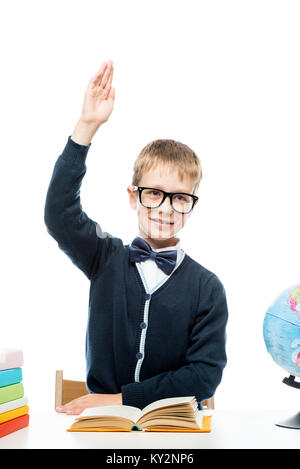 Vertikale Porträt eines Schuljungen Brille an einem Tisch in einem Studio Stockfoto