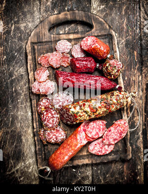 Verschiedene Arten von Salami auf den Brettern. Auf einer hölzernen Hintergrund. Stockfoto