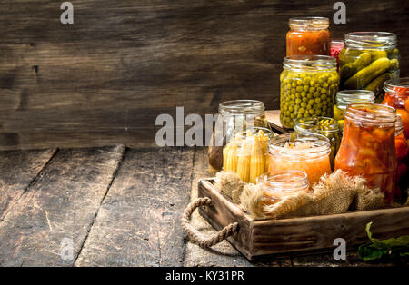 Anders haltbar gemacht Gemüse aus Gemüse und Pilzen, die in Gläsern. Auf einer hölzernen Hintergrund. Stockfoto