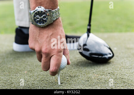 Mann einstellen Golf Ball auf T-Stück Stockfoto