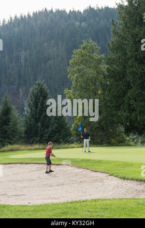 Vater auf seinen Sohn beim Spielen in den Golf Stockfoto