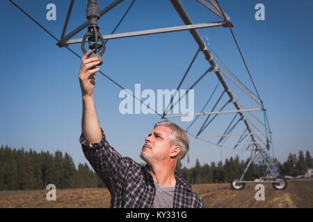 Landwirt Kontrolle Bewässerungssystem im Feld Stockfoto