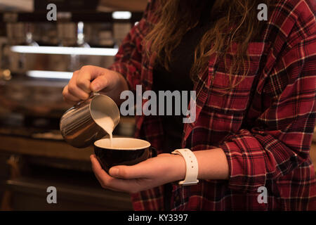 Den mittleren Abschnitt der weiblichen barista Kaffee am Zähler Stockfoto