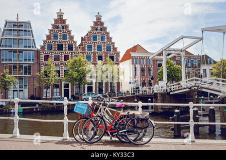 Haarlem, Niederlande. Niederländische Fahrräder am Geländer der am Kanal in der Nähe von einem Anheben der Brücke geparkt. Traditionelle holländische Architektur. Stockfoto