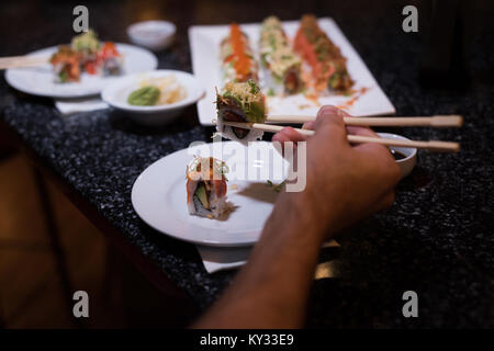 Mann herauf Sushi mit Stäbchen Stockfoto