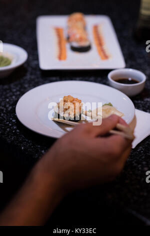 Mann herauf Sushi mit Stäbchen Stockfoto