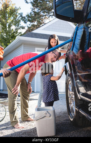 Vater und Kinder, die Spaß beim Waschen Auto Stockfoto