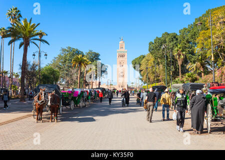 Marrakesch, Marokko - 22. FEBRUAR 2016: Pferdekutsche und outoubia Moschee Jemaa el Fna und Marktplatz in der Medina von Marrakesch. Stockfoto