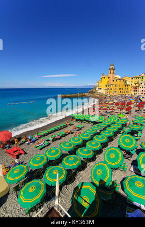 Camogli Italien - Menschen am Strand zu entspannen und die Basilika Santa Maria Assunta im Hintergrund Stockfoto