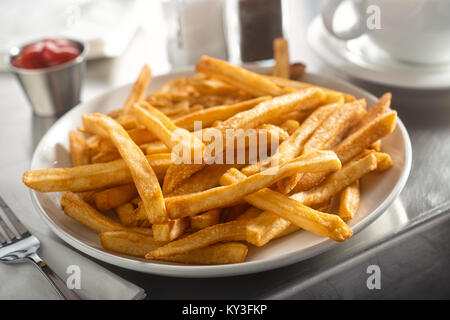 Ein Teller köstliche knusprige Pommes frites in einem Diner serviert auf einem Edelstahl Arbeitsplatte. Stockfoto