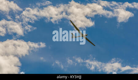 Ein Segelflugzeug fliegen in bleu Sky mit großen weißen Wolken. Der Schirm ist ein Flugzeug, das hat keinen Motor Stockfoto