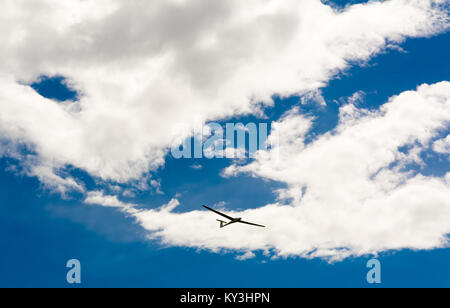 Ein Segelflugzeug fliegen in bleu Sky mit großen weißen Wolken. Der Schirm ist ein Flugzeug, das hat keinen Motor Stockfoto