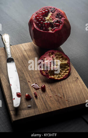 Granatapfel und Samen frisch auf hölzernen Tisch geöffnet Stockfoto