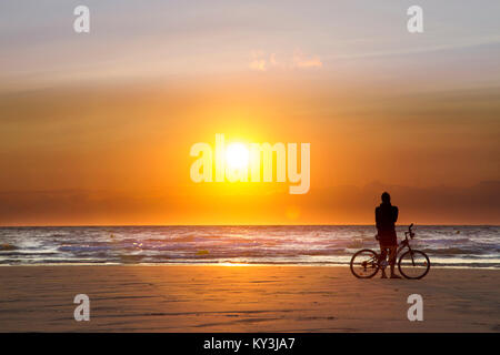 Calais (Frankreich): Radfahrer von hinten am Strand gesehen, mit Blick auf das Meer, den Sonnenuntergang offenkundige "Cote d'Opale' Küste Stockfoto