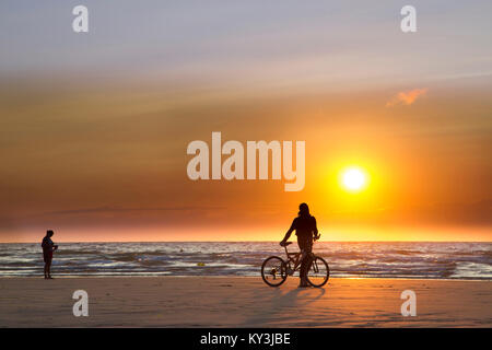 Calais (Frankreich): Radfahrer von hinten am Strand gesehen, mit Blick auf das Meer, den Sonnenuntergang über dem "Cote d'Opale' Küste suchen, und Frau walki Stockfoto