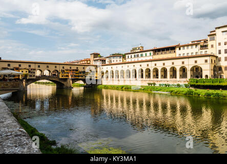 Blick auf die berühmte Brücke Ponte Vecchio von der anderen Seite des Arno in Florenz, Italien, mit Gebäuden im Wasser widerspiegelt Stockfoto