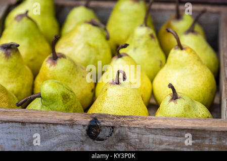 Gelbe Williams (Bartlett) Birnen in Holzbox, Nahaufnahme, Hintergrund. Frisches Obst Anzeige an Markt, Seitenansicht. Stockfoto