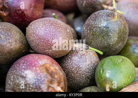 Purple Passion fruit Hintergrund, Nahaufnahme. Frische Passionsfrucht, Maracuja, Passiflora edulis, Parcha angezeigt am Markt, frame Füllung, Makro. Stockfoto