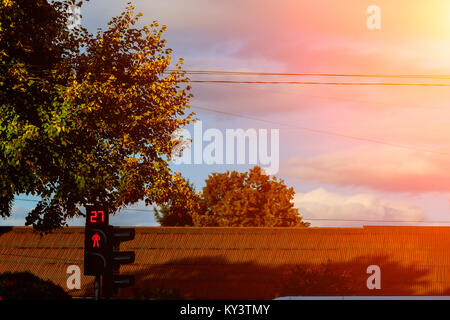 Fußgänger und Radfahrer in bunten Kleidern an der Kreuzung mit der Ampel in der Stadt vor dem Hintergrund der Fassaden Stockfoto