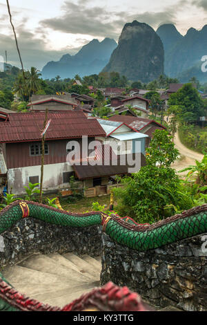 Die traditionellen laotischen Dorf mit Tempel Treppen und Berg Hintergrund in der Nähe von Vang Vieng, Laos. Stockfoto