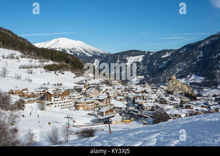 Blick auf das kleine Dorf Ladis im Skigebiet Serfaus Fiss Ladis in Österreich mit schneebedeckten Bergen und blauem Himmel Stockfoto