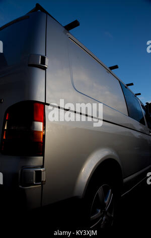 Silber VW Transporter T5 aus dem Abseits der hinteren Perspektive eingefangen. Abbildung zeigt Fahrzeug mit Dachgalerie und einem strahlend blauen Himmel darüber hinaus. Portrait Bild Stockfoto