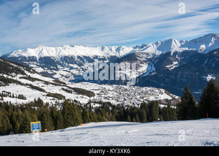 Blick auf das Dorf Fiss mit einer Steigung vor im Skigebiet Serfaus Fiss Ladis in Österreich mit schneebedeckten Bergen Stockfoto