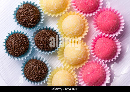 Brasilianische Spezialitäten: Brigadeiro, Beijinho und Bicho de Pe. Kindergeburtstag. Flach Design der Süßigkeit, die Kugel. Makro Nahaufnahme. Stockfoto