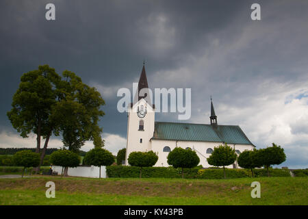 Einsame Kirche im mohnfeld vor dem Sturm Stockfoto