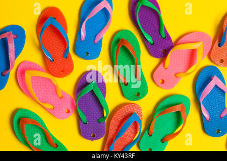 Sammlung von bunten Sommer flip flop Sandalen auf einem hellen gelben Hintergrund Stockfoto