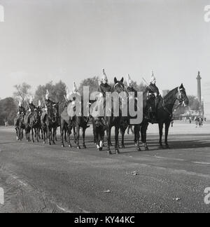 1950, historische, montierte Schutzvorrichtungen des Queen's Household Cavalry in Ausbildung auf dem Exerzierplatz im Whitehall, London, England. Nelson's Column auf traflagar Quadrat kann im Hintergrund gesehen werden. Stockfoto