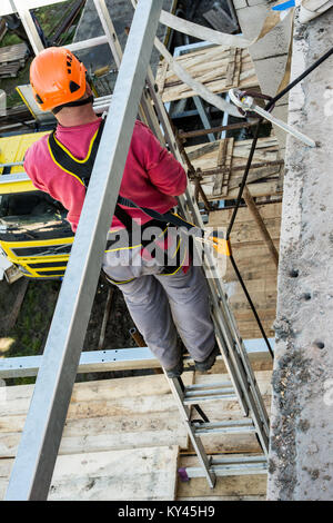 Höhe arbeitet auf dem Aufbau und der Sicherheit. Sichern des Arbeiters während der Arbeit auf einem Gerüst. Stockfoto