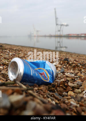 Eine weggeworfene fördert. Bier kann auf einen Kiesstrand gegenüber DP World Container Terminal in Southampton Stockfoto