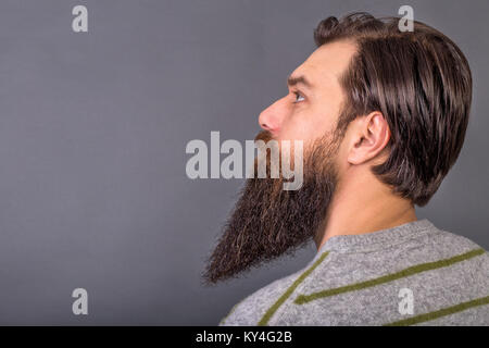 Seitenansicht eines gutaussehenden jungen Mann mit Retro Look über grauer Hintergrund Stockfoto