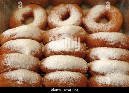 Close up viele frische Ring Donuts mit Zucker Pulver in retail Display Box, hohe Betrachtungswinkel Stockfoto