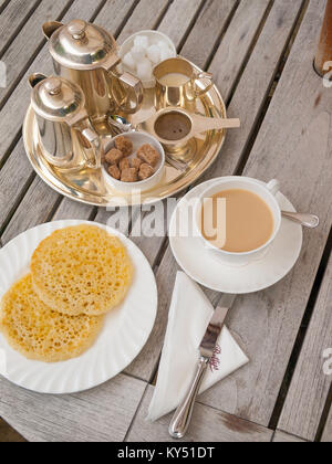 Zwei gebutterte Pikelets Eine regionale Version von CRUMPETS ein Frühstück Snack mit Kaffee in North Yorkshire Café Kaffee serviert Stockfoto