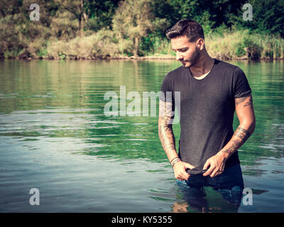 Schöner Mann im Teich Stockfoto