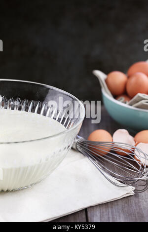 Schale hausgemachter Pfannkuchenteig Mix mit Frische braune Eier im Hintergrund. Extrem geringe Tiefenschärfe. Perfekt für Faschingsdienstag. Stockfoto