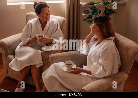 Frauen tragen Bademantel im Warteraum im Spa Salon in Kräutertee und sprechen. Zwei Frauen warten auf Ihren Spa Behandlung. Stockfoto
