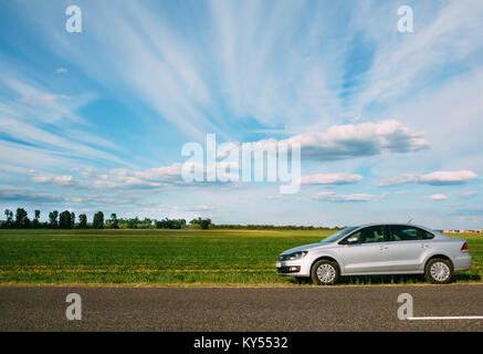 Gomel, Belarus - Juni 13, 2016: Volkswagen Polo stehen auf der Seite der Straße auf dem Hintergrund der schönen Himmel und grünen Felder Stockfoto