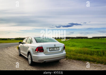 Gomel, Belarus - Juni 13, 2016: Schöne Aussicht auf die Auto Volkswagen Polo in der Landschaft gegen den Himmel und Feld mit einer Straße Stockfoto