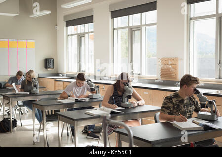 Studenten experimentieren auf Mikroskop im Labor Stockfoto