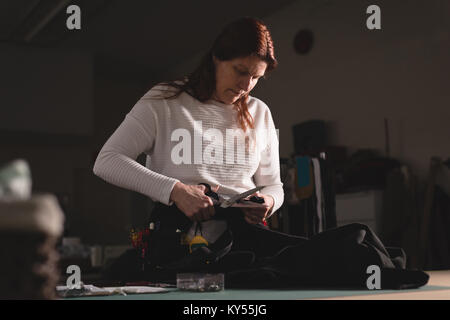 Maßgeschneiderte Kleidung mit der Schere schneiden Stockfoto