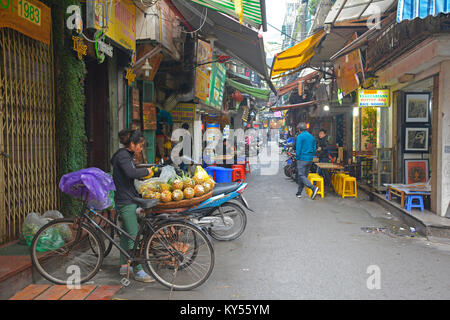 Hanoi, Vietnam - 13. Dezember 2017. Eine Straße Verkäufer bereitet Ananas aus ihr Fahrrad in der historischen Altstadt von Hanoi zu verkaufen Stockfoto